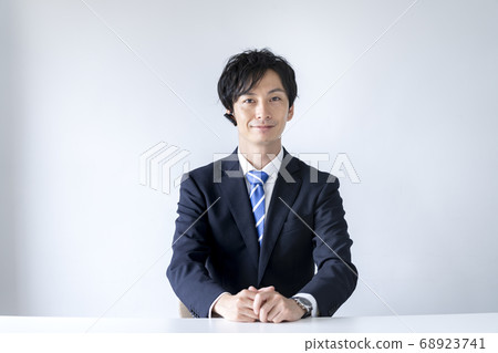 一個穿著西裝的男人戴著耳機，從相機的角度說話 68923741