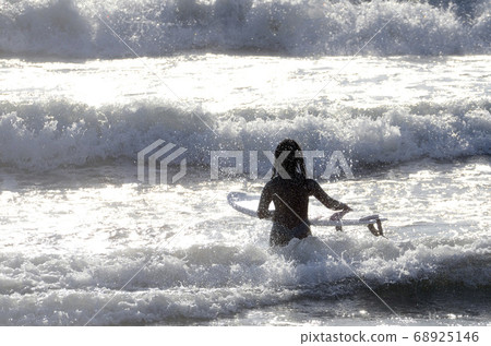 A surfer heading off the coast 68925146