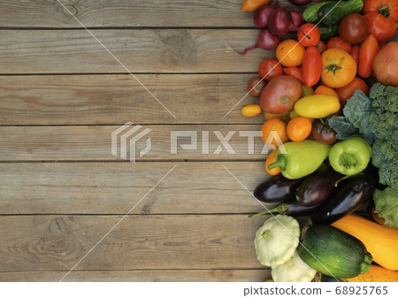 Many different bright, colorful vegetables on a wooden background 68925765