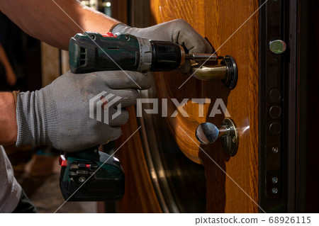 The master worker installs a door lock in the 68926115