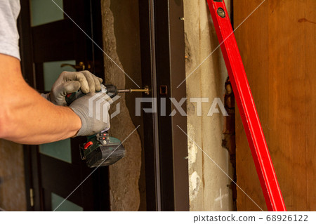 The master mounts a metal door frame, drills holes The master mounts a metal door frame, drills holes 68926122