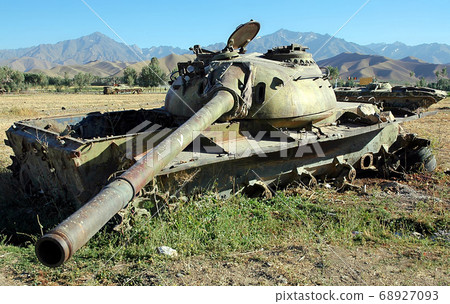 Bamyan (Bamiyan), Central Afghanistan. Destroyed tanks in a field - a reminder of the Afghanistan war. There are many abandoned armored vehicles and weapons from the Afghan war near Bamyan (Bamiyan). Bamyan (Bamiyan), Central Afghanistan. Destroyed tanks in a field - a reminder of the Afghanistan war. There are many abandoned armored vehicles and weapons from the Afghan war near Bamyan (Bamiyan). 68927093