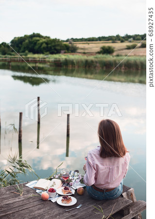 girl enjoying picnic on a wooden pie 68927435