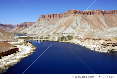 Band-e Amir lakes near Bamyan (Bamiyan) in Central Afghanistan. The blue lakes at Band e Amir national park are formed by travertine dams. Travertine wall, lake and mountains, Band e Amir, Afghanistan Band-e Amir lakes near Bamyan (Bamiyan) in Central Afghanistan. The blue lakes at Band e Amir national park are formed by travertine dams. Travertine wall, lake and mountains, Band e Amir, Afghanistan 68927542