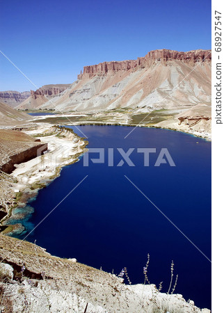 Band-e Amir lakes near Bamyan (Bamiyan) in Central Afghanistan. The blue lakes at Band e Amir national park are formed by travertine dams. Travertine wall, lake and mountains, Band e Amir, Afghanistan Band-e Amir lakes near Bamyan (Bamiyan) in Central Afghanistan. The blue lakes at Band e Amir national park are formed by travertine dams. Travertine wall, lake and mountains, Band e Amir, Afghanistan 68927547