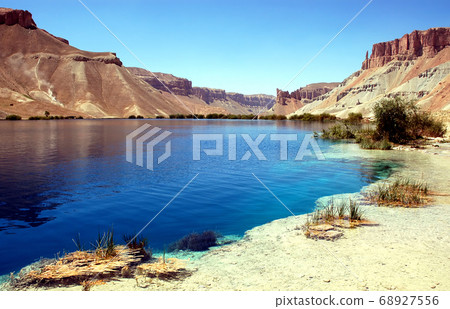 Band-e Amir lakes near Bamyan (Bamiyan) in Central Afghanistan. Band e Amir was the first national park in Afghanistan. View with reeds from the shore of a natural blue lake at Band e Amir Afghanistan Band-e Amir lakes near Bamyan (Bamiyan) in Central Afghanistan. Band e Amir was the first national park in Afghanistan. View with reeds from the shore of a natural blue lake at Band e Amir Afghanistan 68927556