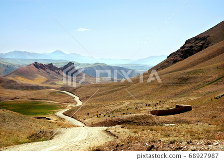 Mountain scenery of Afghanistan near Yakawlang in Bamyan (Bamiyan) Province. These colorful mountains are at the western end of the Hindu Kush mountain range in Central Afghanistan. Dirt road. Mountain scenery of Afghanistan near Yakawlang in Bamyan (Bamiyan) Province. These colorful mountains are at the western end of the Hindu Kush mountain range in Central Afghanistan. Dirt road. 68927987