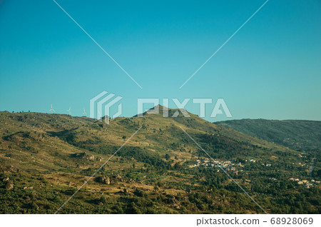 Hilly landscape covered by rocks and some wind turbines Hilly landscape covered by rocks and some wind turbines 68928069