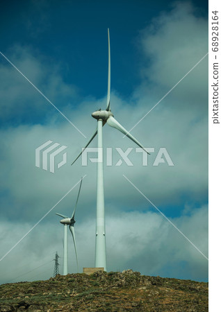 Wind turbines for electric power generation over hilly landscape 68928164