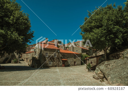 Gothic houses with leafy trees and deserted alley 68928187