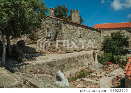 Houses made of stone and flowered garden Houses made of stone and flowered garden 68928335