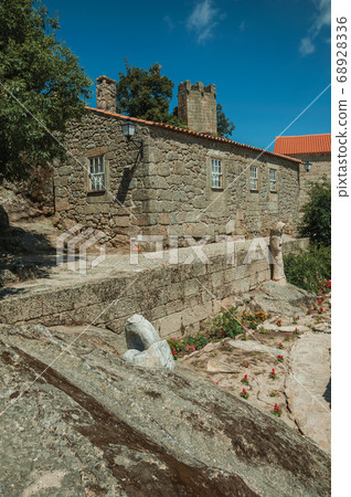 Houses made of stone and flowered garden 68928336