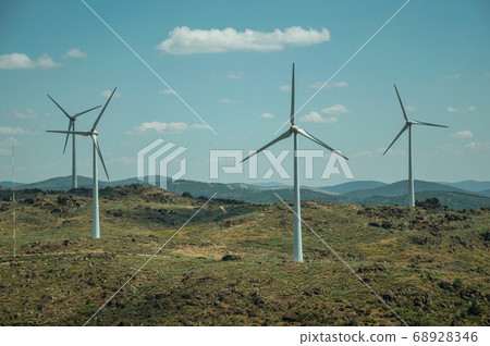 Several wind turbines over hilly landscape 68928346