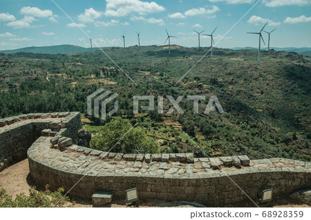 Pathway on thick stone wall and hilly landscape 68928359