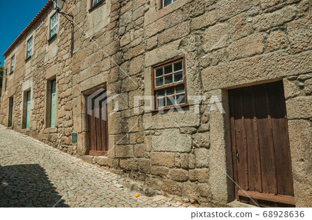 House made of stone with wooden door in an alley House made of stone with wooden door in an alley 68928636