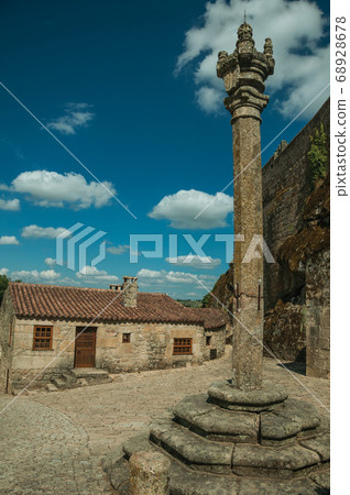 Close-up of stone pillory and gothic house Close-up of stone pillory and gothic house 68928678