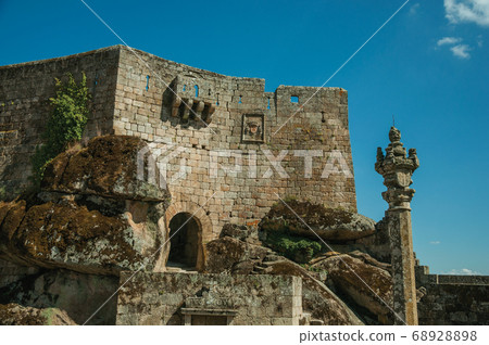 Castle facade with open gateway on stone wall 68928898