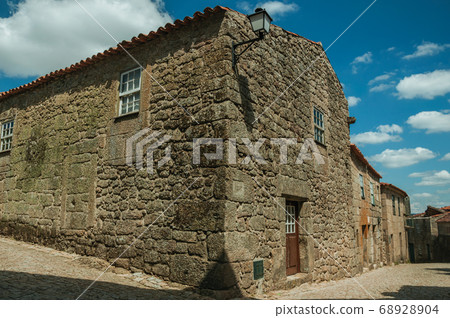 House with wall made of stone in an alley on slope 68928904
