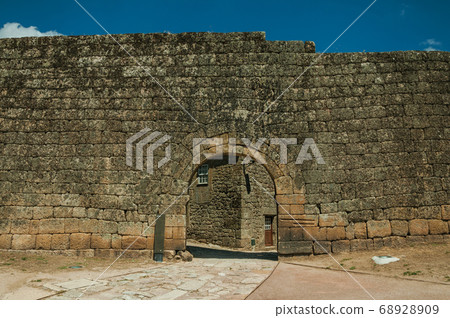 Open gate on a stone outer wall Open gate on a stone outer wall 68928909
