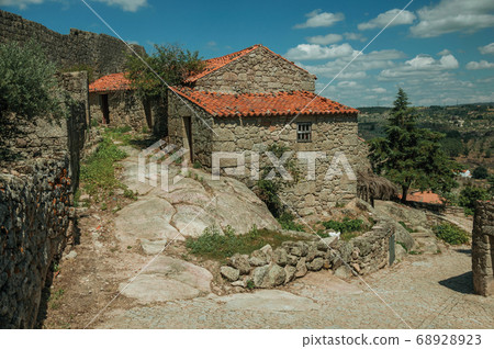 House made of stone in an alley on slope and wall House made of stone in an alley on slope and wall 68928923