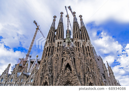 Blue sky, clouds and Sagrada Familia birth facade 68934086