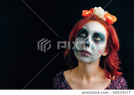 A young woman in day of the dead mask skull face art. 68934577