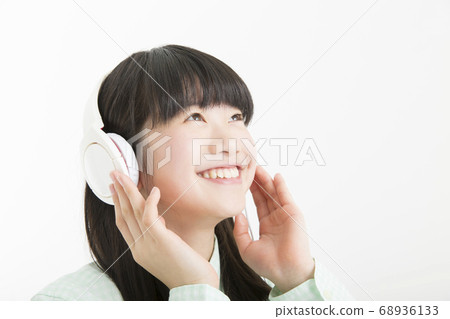 Girl listening to music on headphones 68936133