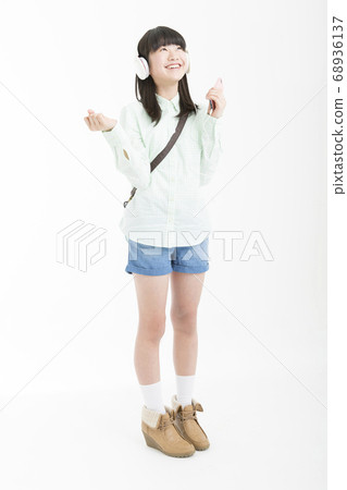 Girl listening to music on headphones Girl listening to music on headphones 68936137