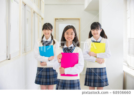 Female junior high school students lining up in the hallway with a smile Female junior high school students lining up in the hallway with a smile 68936660