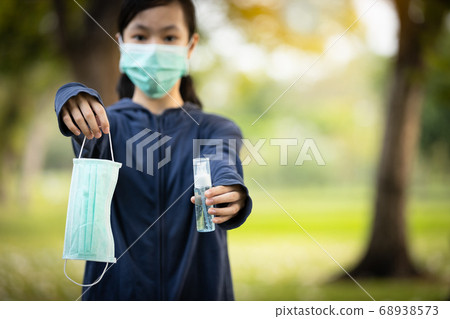 Asian child girl hold a protective mask and bottle of alcohol antiseptic gel,equipment for disinfection,pandemic of Covid-19,Coronavirus outbreak,hand sanitizer to protect against contagious disease Asian child girl hold a protective mask and bottle of alcohol antiseptic gel,equipment for disinfection,pandemic of Covid-19,Coronavirus outbreak,hand sanitizer to protect against contagious disease 68938573