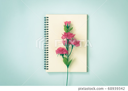 Spiral Notebook and Rose Flower at Center on Pastel Minimalist Background in Vintage Tone 68939342