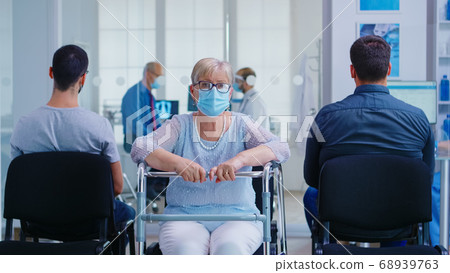 Senior woman with walker in hospital waiting area 68939763
