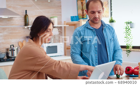 Man chopping tomatoes on wooden board 68940010