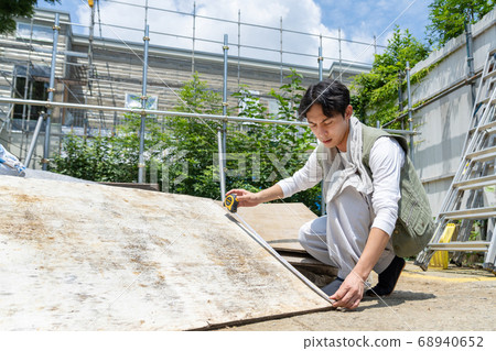 在一個建築工地工作的年輕木匠人 68940652