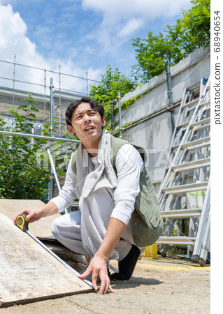 在一個建築工地工作的年輕木匠人 68940654