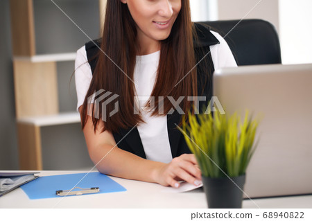 Shot of an attractive young businesswoman working on a laptop at her workplace. 68940822