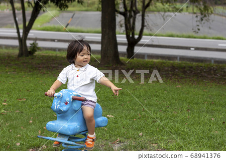 Girl playing with statue spring playground equipment Girl playing with statue spring playground equipment 68941376