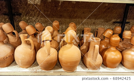 Rustic handmade brown terracotta vases and cups at the pottery shop in Avanos. Ceramic clay souvenirs at handicraft market in Cappadocia, Turkey Rustic handmade brown terracotta vases and cups at the pottery shop in Avanos. Ceramic clay souvenirs at handicraft market in Cappadocia, Turkey 68942425