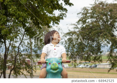 Girl playing with blue-green pig spring playground equipment Girl playing with blue-green pig spring playground equipment 68942525