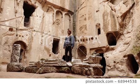 Man alone at ancient Gumusler Monastery surrounded by old stones and ruins in Gumusler, Nigde Man alone at ancient Gumusler Monastery surrounded by old stones and ruins in Gumusler, Nigde 68944538
