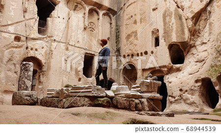Man alone at ancient Gumusler Monastery surrounded by old stones and ruins in Gumusler, Nigde Man alone at ancient Gumusler Monastery surrounded by old stones and ruins in Gumusler, Nigde 68944539