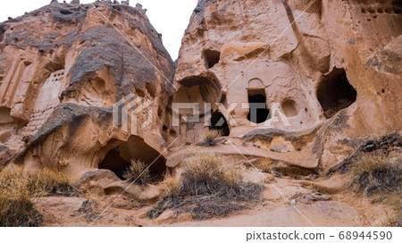 Fairy chimneys and cave houses surrounded by rock formations at Zelve Valley in Cappadocia, Turkey 68944590