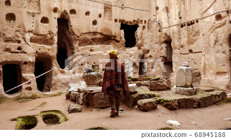 Woman alone at ancient Gumusler Monastery surrounded by old stones and ruins in Gumusler, Nigde Woman alone at ancient Gumusler Monastery surrounded by old stones and ruins in Gumusler, Nigde 68945188