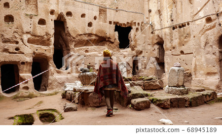 Woman alone at ancient Gumusler Monastery surrounded by old stones and ruins in Gumusler, Nigde Woman alone at ancient Gumusler Monastery surrounded by old stones and ruins in Gumusler, Nigde 68945189