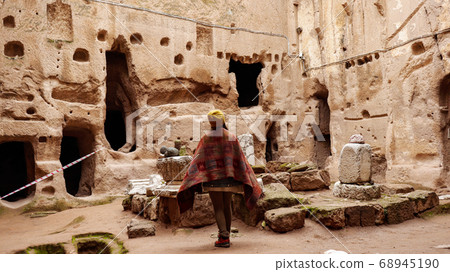 Woman alone at ancient Gumusler Monastery surrounded by old stones and ruins in Gumusler, Nigde Woman alone at ancient Gumusler Monastery surrounded by old stones and ruins in Gumusler, Nigde 68945190