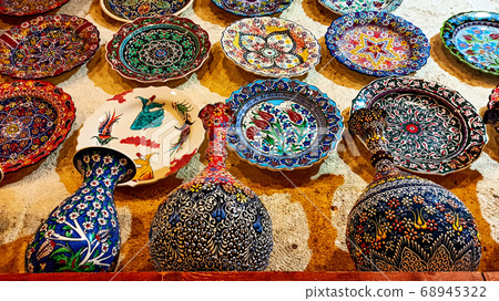 Hittite wine vessels, colorful ceramic vases and porcelain bowls in a underground cave atelier in Avanos in Cappadocia. Turkish traditional ceramic handycrafts in a local pottery shop in Cappadocia 68945322