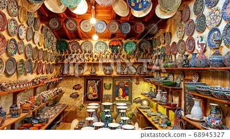 Hittite wine vessels, colorful ceramic vases and porcelain bowls in a underground cave atelier in Avanos in Cappadocia. Turkish traditional ceramic handycrafts in a local pottery shop in Cappadocia 68945327