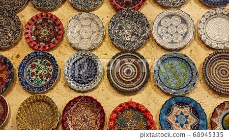 Hittite wine vessels, colorful ceramic vases and porcelain bowls in a underground cave atelier in Avanos in Cappadocia. Turkish traditional ceramic handycrafts in a local pottery shop in Cappadocia Hittite wine vessels, colorful ceramic vases and porcelain bowls in a underground cave atelier in Avanos in Cappadocia. Turkish traditional ceramic handycrafts in a local pottery shop in Cappadocia 68945335