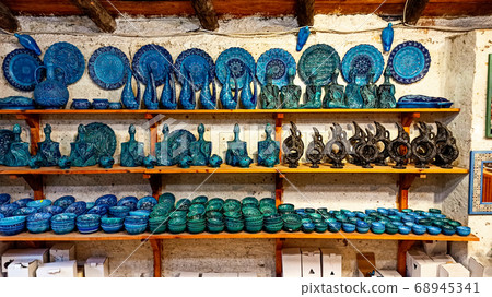 Hittite wine vessels, colorful ceramic vases and porcelain bowls in a underground cave atelier in Avanos in Cappadocia. Turkish traditional ceramic handycrafts in a local pottery shop in Cappadocia 68945341