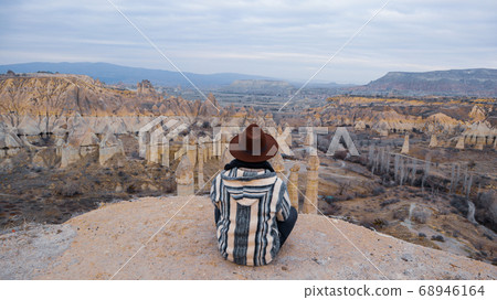 Man watching the volcanic landscape at the valley of love in Goreme, Cappadocia Man watching the volcanic landscape at the valley of love in Goreme, Cappadocia 68946164